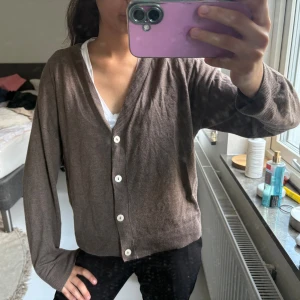 Brun kofta med v-ringning och knappar - Säljer en brun kofta med v-ringning och vita knappar framtill från mango. Koftan har långärmad passform och är verkligen mjuk. 