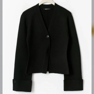 Svart kofta från Gina Tricot - Köp direkt för 400!!!Stilren svart kofta från Gina Tricot med v-ringning och två knappar framtill. Koftan har långa ärmar med breda uppvik och knappdetalj vid ärmslut. Perfekt till jeans eller kjol för en clean look.