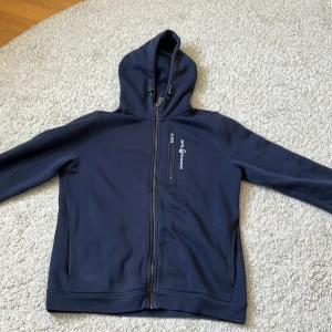 Mörkblå SailRacing kofta - Säljer den här fina tröjan från SailRacing då den inte kommer till användning❤️‍🔥Använd många gånger men i bra skick. Finns en tråd som syns på framsidan för att hålla innerfickan på plats😻storlek 170 men sitter som S.