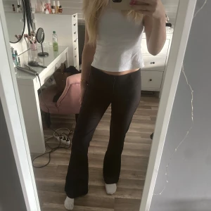 Svarta kostymbyxor - Säljer ett par svarta  kostymbyxor med raka ben och snygg passform. Byxorna har fickor bak med knappdetalj och stängs med dragkedja och knapp framtill. Dom har blivit noppriga vid midjan och på fickorna bak!