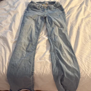 Ljusblå wide jeans från Nelly - Säljer ett par ljusblå jeans från Nelly med rå, fransad midja och klassiska fem fickor. Jeansen har en wide passform med raka, vida ben och är tillverkade i mjukt denimtyg. Perfekta för en avslappnad och trendig look.