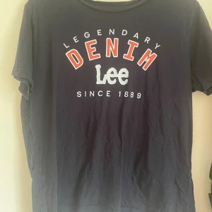 Mörkblå Lee t-shirt🤍 - Snygg mörkblå t-shirt från Lee med stort tryck framtill där det står 'Legendary Denim Lee Since 1889'. Modellen är relaxed fit och har klassisk rund hals och korta ärmar. Perfekt för en chill och avslappnad stil🫶🏻
