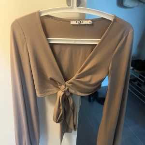 Topp med ballongärm - Super fin långärmad topp som har ballongärmar, är använd ett fåtal gånger och är mycket bra skick!  ”Snöret” knyts ihop där bak (se bild 4)  Normal i storleken.
