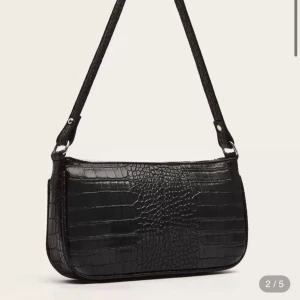 Svart axelväska i krokopräglat skinn - Stilren svart axelväska med krokodilpräglat mönster och silverfärgad dragkedja. Väskan har en avlång form och ett beige innerfoder. Perfekt för dig som vill ha en trendig accessoar med edgy vibe.  Nypris: 94 kr 🌟💕 #Väska #😍 Vinted #Fynd #Secondhand #fashion #VintedUK #selling #Kappa #Coat #Kappa #Jacka #Bag #Väska #❤️