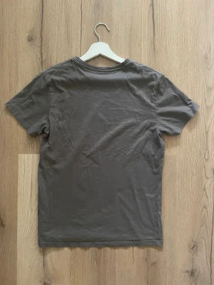 En stilren grå T-shirt från Kappahl ✨✨ - ✨ Grå Kappahl T-shirt – enkel, stilren & superfräsch! Perfekt basplagg som funkar året runt. Sitter snyggt och är i riktigt fint skick 👌  📐 Mått: • Axelbredd: 44 cm • Längd: 66 cm  💸 Pris: 89 kr 🚀 Skicka gärna ett meddelande om du vill köpa – först till kvarn!