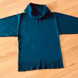 Mörkblå polotröja med ribbade detaljer - Snygg mörkblå polotröja från Arket med bred polokrage och ribbade muddar vid ärmslut och nederkant. Tröjan har trekvartsärm och är tillverkad i mjuk bomullsmix, perfekt för lager-på-lager under hösten och vintern.