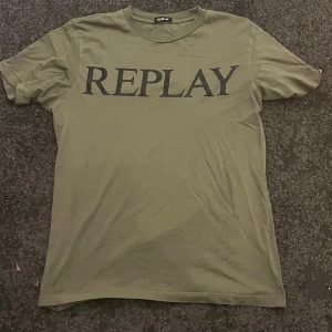 Olivgrön t-shirt från Replay - Snygg olivgrön t-shirt från Replay med stor svart logotyp på bröstet. Klassisk rund hals och korta ärmar. Perfekt för dig som gillar stilrena och enkla plagg med tydlig branding. Mjuk och skön bomullskvalitet.
