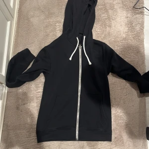 Pier one hoodie  - Svart hoodie från Pier One med vit snörning i huvan och hel dragkedja framtill. Tröjan har två stora fickor på magen och är långärmad. Perfekt för chill dagar och har en clean look med klassisk passform.