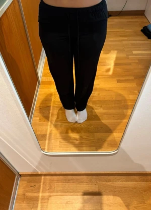 Svarta mjukisbyxor från STR, storlek S - Svarta mjukisbyxor från STR med normal passform och rak i modellen. Byxorna har resår i midjan med snörning för extra komfort. Perfekta för chill dagar eller när du vill ha något riktigt bekvämt på dig.