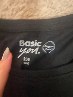 Svart långärmad tröja Basic You - En svart långärmad tröja från Basic You i storlek 158/164. Tillverkad av mjuk ekologisk bomull, perfekt för dig som gillar enkla och stilrena plagg. Rund halsringning och klassisk passform som funkar till många olika looks.