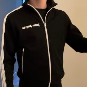 🖤 Palm Angels Track Jacket – Black/White (Unisex, Size S) - Superfräsch äkta Palm Angels track jacket, ikonisk modell i svart med vita stripes. Perfekt fit, snygg kvalitet och klassiskt tryck på bröstet. Sitter riktigt snyggt – både chill och lyxig på samma gång.  ✅ Äkta (QR-tag finns) 📏 Storlek S ✨ Skick: 9/10 💰 Nypris ca 4500 kr  Säljer pga rensning – grym deal för dig som vill ha en riktigt fräsch fleece 👀 