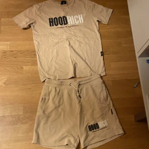 Beige Hoodrich set med snörning XS - Säljer ett  beige Hoodrich set i mjuk bomull med broderad logga i svart och vitt framtill. Modellen har snörning i midjan och normal passform, perfekt för chill dagar. Fickor på sidorna och stilren design som matchar streetwear-viben.Tröjan är även av skönt material och har perfekt passform.Hoodrich loggorna har speciellt material som sticker ut lite.