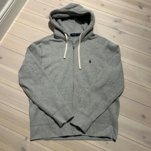 Ralph Lauren  - Säljer den klassiska Ralph Lauren hoodien i grå med dragkedja | mycket bra skick, inga defekter | storlek L | qr kod finns | nypris 2300kr| pris går att diskutera vid snabb affär | perfekt till kyligare dagar❄️| obs tvättlappen är bortklippt