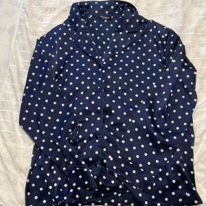 Blå prickig pyjamas set från Change - Super mjuka silk matching pyjamas set från Change, blå och vita prickig design med knappar och lång armad sleeves. OBS: Tröjan är M och byxorna är L