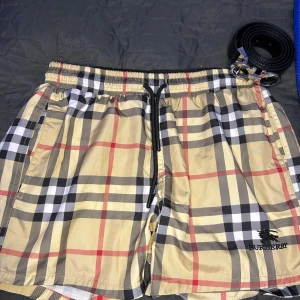  Burberry shorts - Snygga Burberry shorts i klassiskt rutig design med beige, svart, vit och röda toner. Helt nytt skick, Storlek small, Kontakta mig om du är intresserad