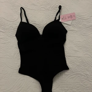 Svart korsettbody från H&M - Den populära bodyn från H&M 💕 Slutsåld överallt!!🔥✨💗 . Snygg och tight passform som framhäver siluetten. Helt ny med tagg kvar. Kan tänka mig att gå ner i pris vid snabb affär🥰