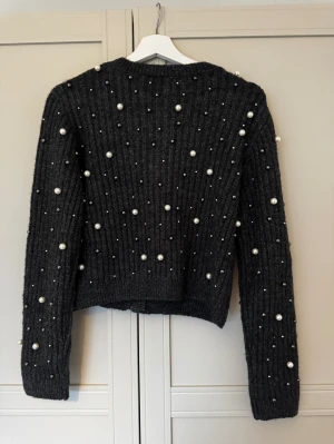 Stickad kofta pärlor H&M S - Superfin kofta med pärlor från H&M. Färgen är mörkgrå Endast testad aldrig kommit till användning, lappar borttagna. Nypris 499kr