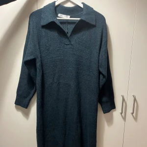 Mörkblå stickad klänning från Zara - Mysig mörkblå stickad klänning från Zara med krage och v-ringad hals. Klänningen har lång ärm och rak passform. Knappt använd!