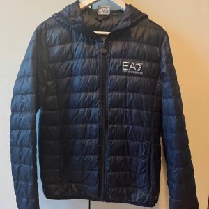 Armani Vindjacka - Säljer min vindjacka från Armani. Jackan är i bra skick förutom en lite reva på höger arm som lätt går att laga.