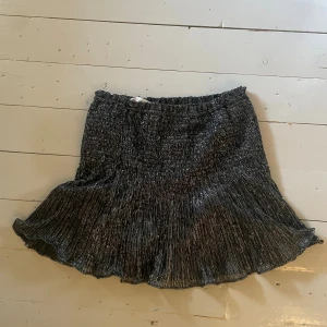 Glittrig svart kortkjol med volang - Säljer en glittrig svart kortkjol med bred volang nedtill. Stretchig midja och har inbyggda shorts! ❤️ Från Zara 