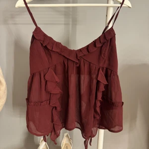 Vinröd volangig linnetopp - Helt oanvänd fest topp från Bikbok. (Utan lapp tyvärr) Triangel urringning men supersnygg passform! Säljer då den inte kommer till användning.