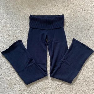 Mörkblå stickade yogapants - Mysiga mörkblå stickade yogapants från Gina Tricot med bred ribbad midja. Passar alla upp till 160 cm långa och neråt. Byxorna har en relaxed passform och är perfekta för chill dagar. Materialet är mjukt och stretchigt för extra komfort.