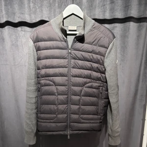 Grå Moncler cardigan - Jag säljer en grå Moncler cardigan som är väldigt sällsynt och den säljs ej längre. Cardiganen är i jätte bra skick och den är såklart äkta. Storlek M, nypris 12 000kr mitt pris 2999kr, priset kan diskuteras 
