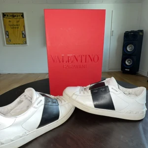 Valentino Garavani Open sneakers vit/svart - Säljer ett par Valentino Garavani Open sneakers i storlek 43. Skorna är såklart använda så de är kreasade lite, dom är äkta, köpt från merchsweden säljs för 3500kr box med följer 