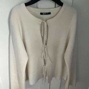 Vit kofta med knyt från Gina Tricot - Superfin vit kofta från Gina Tricot med trendiga knyt framtill. Koftan har lång ärm och är tillverkad i ett mjukt material som känns skönt mot huden. Perfekt att slänga över en topp för en chill look.