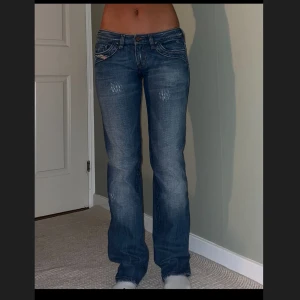 Diesel straight leg jeans blå, stl 29 - Snygga blå  straight leg jeans från Diesel med låg midja. Jeansen har slitna detaljer framtill och coola kontrastsömmar. 