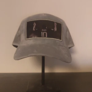 Grå keps med Messi-tryck - Jag beställde denna keps men den var inte min smal tyvärr, den är aldrig använd och den är såklart riktigt fräsch, hör av dig för fler frågor!
