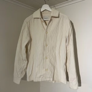 Vit Overshirt med knappar - These Glory Days  - Säljer denna sjukt snygga Overshirten från These Glory Days⭐️ Färgen är vit och storleken är S✅ Overshirten har inga defekter och skicket är utomordentligt🙌🤝 Sjukt najs passform och passar perfekt till hösten🍁🙌 Nypris 1300. Tveka inte på att höra av er dig vid minsta fråga eller fundering😊