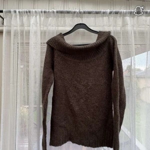 Brun offshoulder stickad tröja - Tycker den är för sticking för min smak men den är super fin. Mysig brun stickad tröja med bred ribbad krage som sitter offshoulder. Långärmad modell med avslappnad passform, perfekt för lager på lager under kyliga dagar. Enkel att styla med både jeans och kjol. Storlek S/M