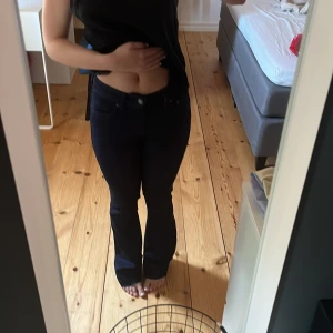 Mörkblå bootcut jeans - Säljer ett par mörkblå jeans med bootcut-modell och klassisk femficksdesign från ZARA. Jeansen har normal passform och är tillverkade i ett stretchigt denimtyg som sitter snyggt över höfterna och släpper ut vid bensluten. De är i storlek 32 och avklippta nedtill för att passa mig i längden, som referens så är jag 1,63🥰Aldrig använda men lappen är bortklippt.❤️