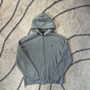 Grå hoodie från Polo Ralph Lauren - Hoodien är knappt använd och fortfarande i väldigt bra skick, tvättad ett fåtal gånger! Pris går att diskutera 
