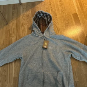 Grå hoodie från Burberry med rutig huva - Aldrig använd precis köpt ny skick. Storlek M pris kan diskuteras 
