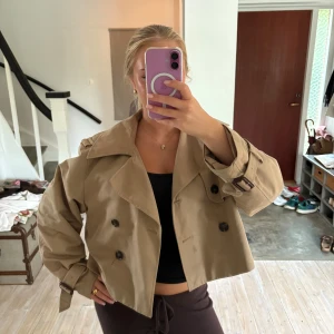 Beige croppad trenchcoat från HM  - Säljer den virala hm trenchcoaten! Den har inga hål eller fläckar och är inte så använd. 