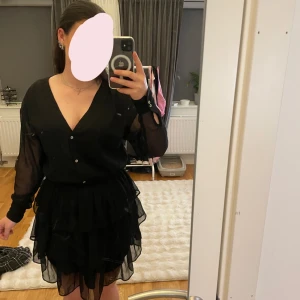 Svart volangklänning med v-ringning - Säljer en superfin svart kortklänning med v-ringning. Använd en gång💗