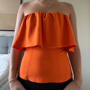 Orange tuptopp med volang - Snygg orange topp med volang. Aldrig använd, så i helt nytt skick. Tryck inte på KÖP DIREKT utan skriv privat om du är intresserad! 💛