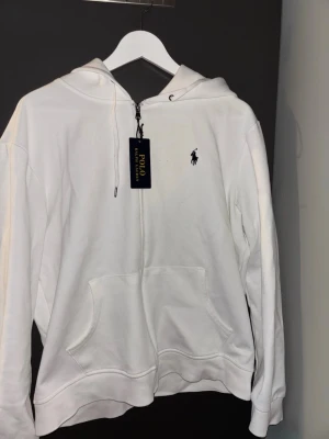 Polo ralph lauren  - Vit polo Ralph Lauren zip up hoodie nytt skick passar till allt.Säljer den på grund av att jag skulle vilja köpa en svart sån men större storlek. Kontakta mig gärna i Dm för mer information.