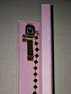 Himo klock set - Stilren och snygg guld klocka med svart urtavla, använt ett par gånger men har inga skador eller reppor. Inkluderar ett snyggt vändbar armband med i settet.