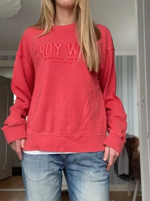 Sweatshirt med tryck - Säljer en oversized rosa sweatshirt med text framtill. Tröjan har långa ärmar, ribbade muddar och avslappnad passform. Supersnygg lite washed-out blek röd färg.