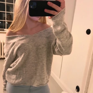 Ljusgrå offshoulder stickad tröja - Mysig ljusgrå stickad tröja med offshoulder-design och lång ärm. Vringad
