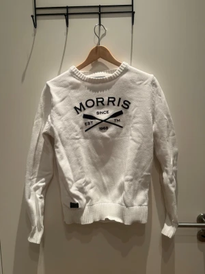 Stickad tröja Morris  - Vit stickad tröja från Morris  med rund halsringning och svart broderad logga framtill. Inga defekter