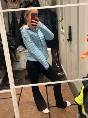 Ljusblå pufferjacka från Colmar - Säljer en snygg ljusblå pufferjacka från Colmar Originals. Jackan har huva, dragkedja framtill och två fickor med dragkedja. Den är quiltad och har en klassisk Colmar-logga på ärmen. Perfekt för kyliga dagar och riktigt skön att ha på sig.