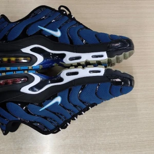 Nike Air Max Plus blå och svarta - Nike Air Max Plus sneakers i blått och svart med vita detaljer och synlig Air Max-sula. Skorna har vågformade svarta linjer, blå mesh-överdel och tydlig TN-logga på hälen. Swoosh-logga i ljusblått på sidan. Perfekta för dig som gillar streetwear och snygg design. Box ingår ej