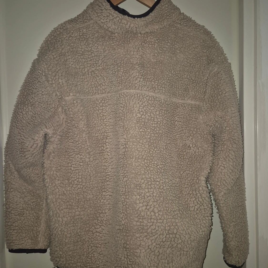 Beige teddyjacka med svart ficka - 1