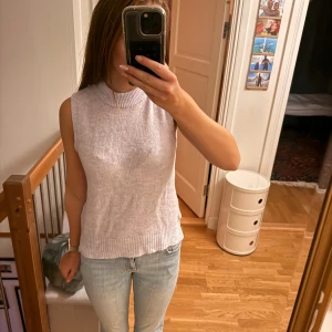 Ljuslila stickad topp - Säljer en ljuslila stickad topp med hög hals och ribbade kanter. Toppen är ärmlös och har en mjuk, bekväm känsla som passar perfekt till jeans eller kjol. Enkel och stilren design som är lätt att matcha. Säljer då jag ej tycker den passar min stil. Priset kan diskuteras. Aldrig använd!!