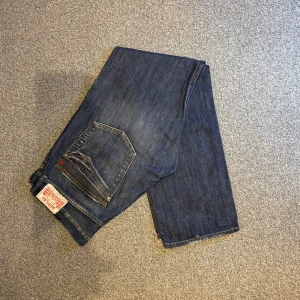 Replay blue jeans W36/L34 - Replay blue jeans i storlek W36/L34. Mörkblåa jeans med skönt material. Bra skick utan hål eller fläckar. Nypris runt 1500–2000 kr.  Mått: A (midja): 50 cm B (lårvidd): 34 cm C (fotvidd): 23 cm D (innerbenslängd): 86 cm  Säljes för 299 kr.  