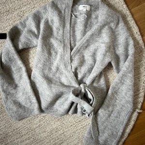 Grå Kofta  - Grå knytkofta från Ginatricot i fint skick. Passar S-M